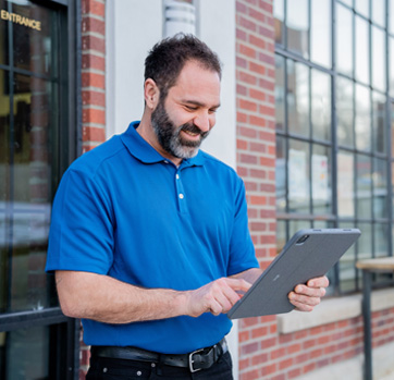 Fidelity technician holding a tablet outside of a business