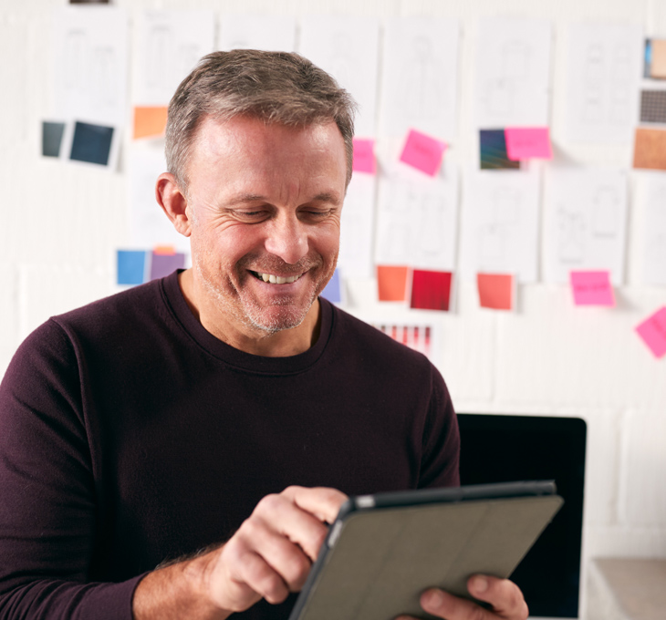 Man smiling while touching an iPad screen